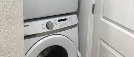 A stacked washer and dryer unit in a laundry room.