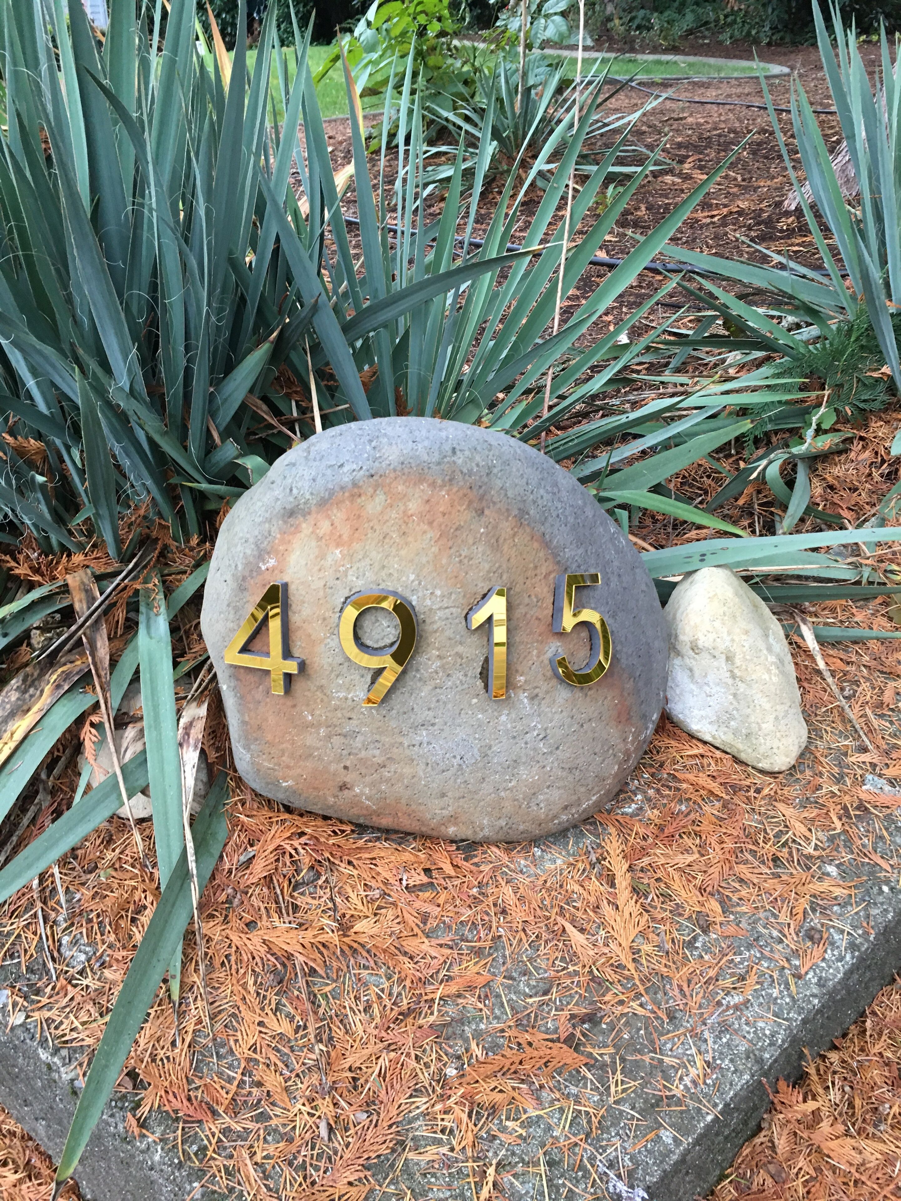 A stone house number plaque with the number 4915.