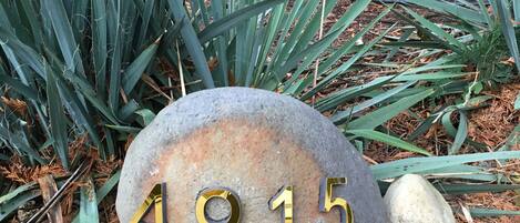 A stone house number plaque with the number 4915.