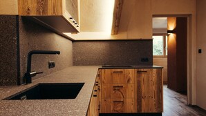 A modern kitchen with a granite countertop, wooden cabinets, and a black faucet. - Holiday Apartment "Obertimpflerhof Lola" with Mountain View, Private Terrace & Wi-Fi (Verano)