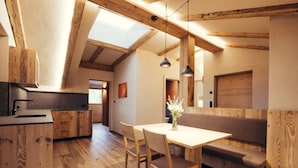 A modern kitchen with wooden beams, a dining area with a bench, and a skylight. - Holiday Apartment "Obertimpflerhof Lola" with Mountain View, Private Terrace & Wi-Fi (Verano)