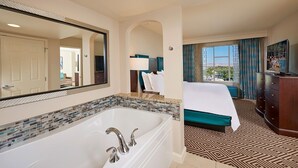 A hotel room with a large bathtub, a bed with a view, a TV, and a dresser. - Paradise, a Hilton Grand Vacations Club near the Las Vegas Convention Center (Las Vegas)