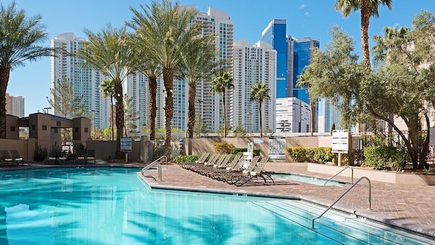 A swimming pool with lounge chairs and palm trees, surrounded by high-rise buildings. - Paradise, a Hilton Grand Vacations Club near the Las Vegas Convention Center (Las Vegas)