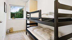 A bunk bed room with a window, a small rug, and a wooden cabinet. - "Berta" - 70m to the fjord by Interhome (Roslev)