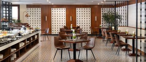 A restaurant with a tiled floor, wooden panel walls, and a buffet area with various food items.