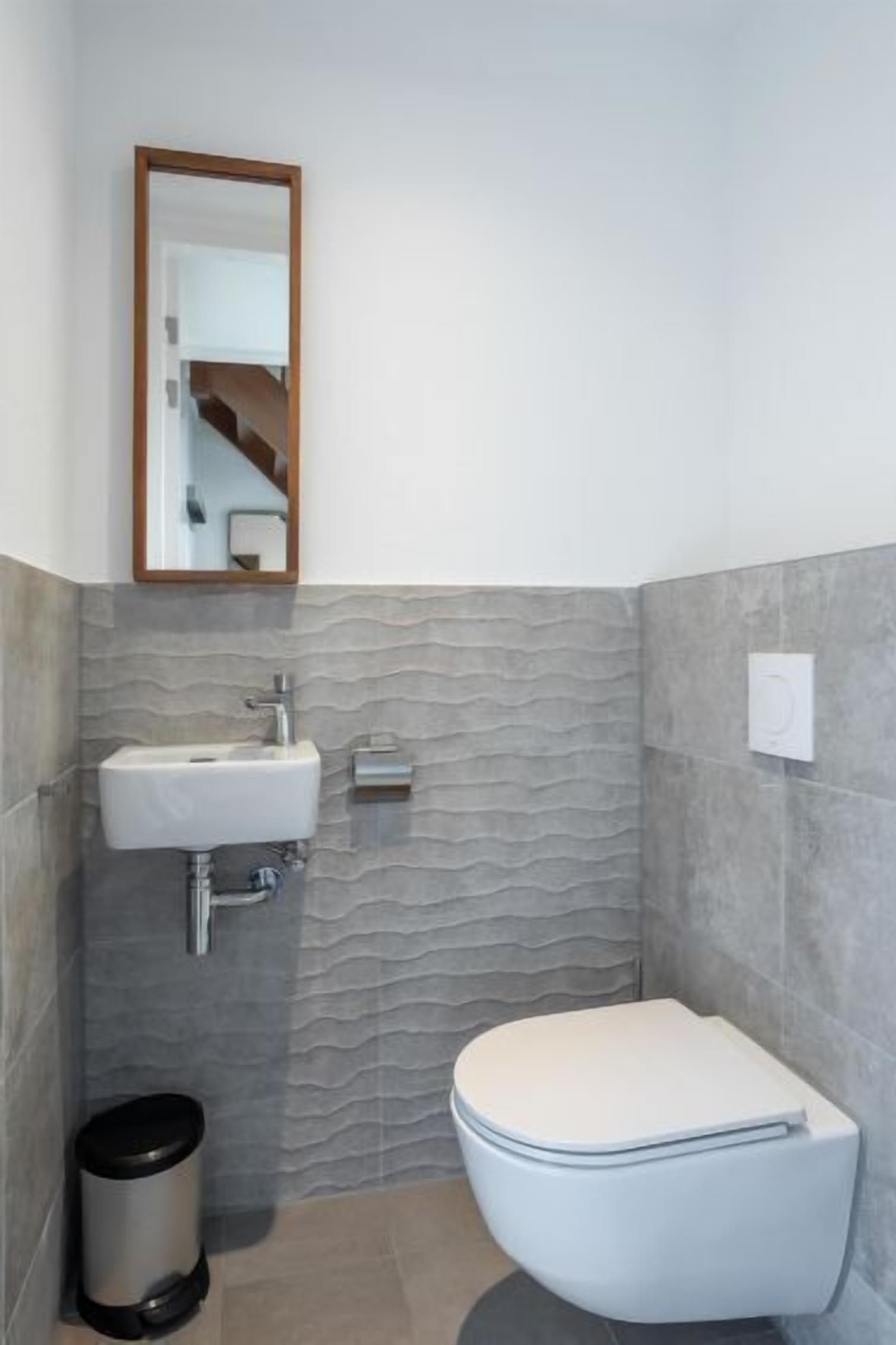 Ein Badezimmer mit Waschbecken, Toilette und Mülleimer.