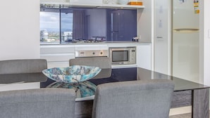 A modern kitchen with a built-in microwave, a stove, and a refrigerator. - Circle on Cavill - Stunning River Views! (Surfers Paradise)