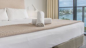 A hotel room with a bed, a view of the water, and a cityscape. - Circle on Cavill - Stunning River Views! (Surfers Paradise)