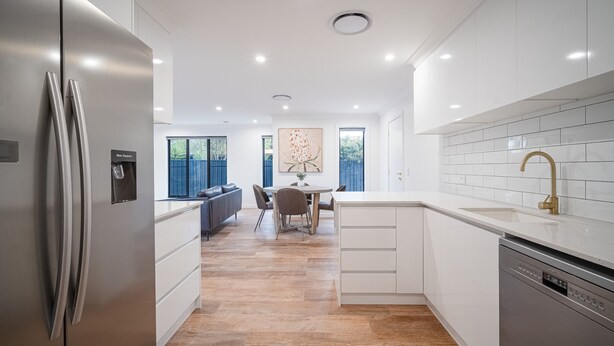 A modern kitchen with white cabinetry, a stainless steel refrigerator, and a gold faucet. - Elegance and Style (Wagga Wagga)