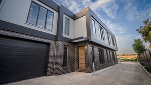 A modern two-story building with a garage door, large windows, and a brick facade. - Elegance and Style (Wagga Wagga)
