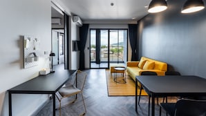 Un salon moderne avec un canapé, une table à manger et un téléviseur fixé au mur.