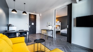 Une chambre d’hôtel moderne comprenant un coin repas, un canapé, une petite table et un lit.