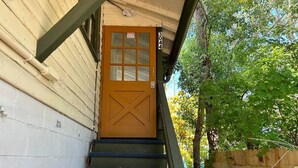 A wooden door with a window, a number '3044' above it, and a wooden fence in the background. - Tree Top Getaway- Sleeps 4 (Gulfport)