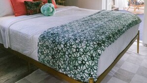 A bedroom with a bed, a ceiling fan, a round mirror, and a door leading to a balcony. - Tree Top Getaway- Sleeps 4 (Gulfport)