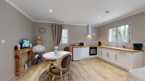 Een compacte keuken met een eethoek, houten vloeren en een kleine tafel met stoelen.