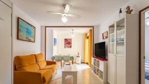 A living room with a sofa, a coffee table, a TV, and a cabinet.