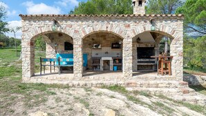 A stone building with three arches, a small tower, and a bench outside. - Holiday Home "Horrio" with Mountain View, Shared Pool & Wi-Fi (Querol)