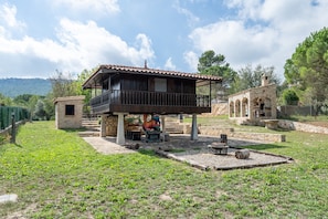 A rustic villa with a balcony, a stone building, and a grassy yard. - Holiday Home "Horrio" with Mountain View, Shared Pool & Wi-Fi (Querol)