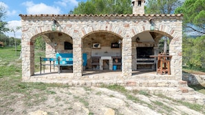 A stone building with three arches, a bench, and a table. - Chalet "Can Tronc" with Mountain View, Shared Pool & Wi-Fi (Querol)