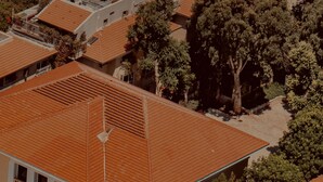 A residential area with multiple buildings featuring red-tiled roofs and balconies.