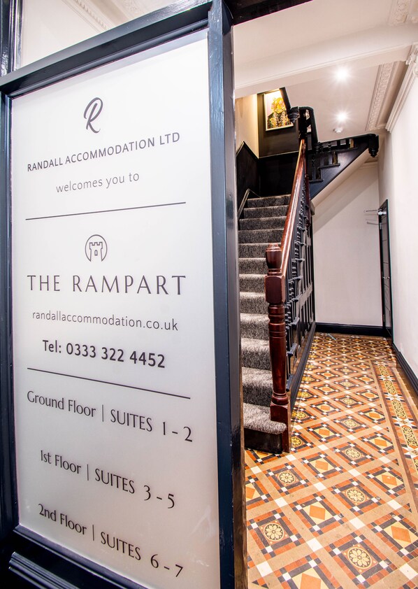 Une enseigne indiquant l’emplacement de l’hôtel The Rampart, qui possède un escalier menant au rez-de-chaussée.