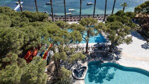 A resort with a swimming pool, lounge chairs, and a view of the sea. - Ömer Prime Holiday Resort (Kusadasi)