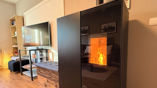A modern living room with a flat-screen TV, a sofa, a glass-top coffee table, and a fireplace. - Gemütliche, Vollausgestattete Wohnung für 4 Personen im Ruhrgebiet (Castrop-Rauxel)