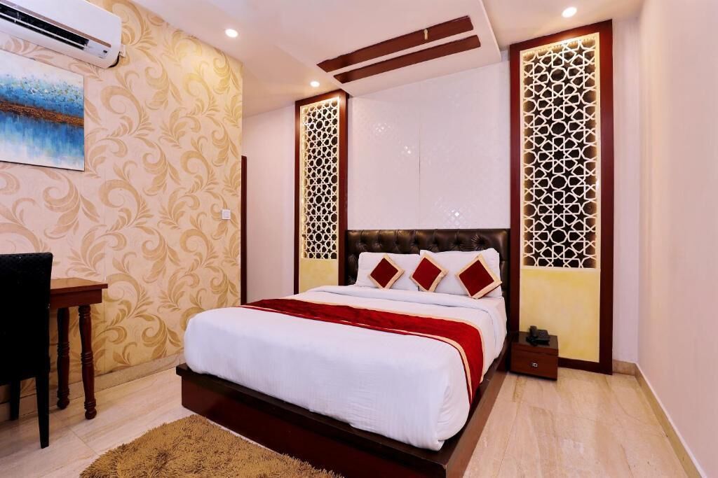 A bedroom with a bed, a desk, and decorative panels.
