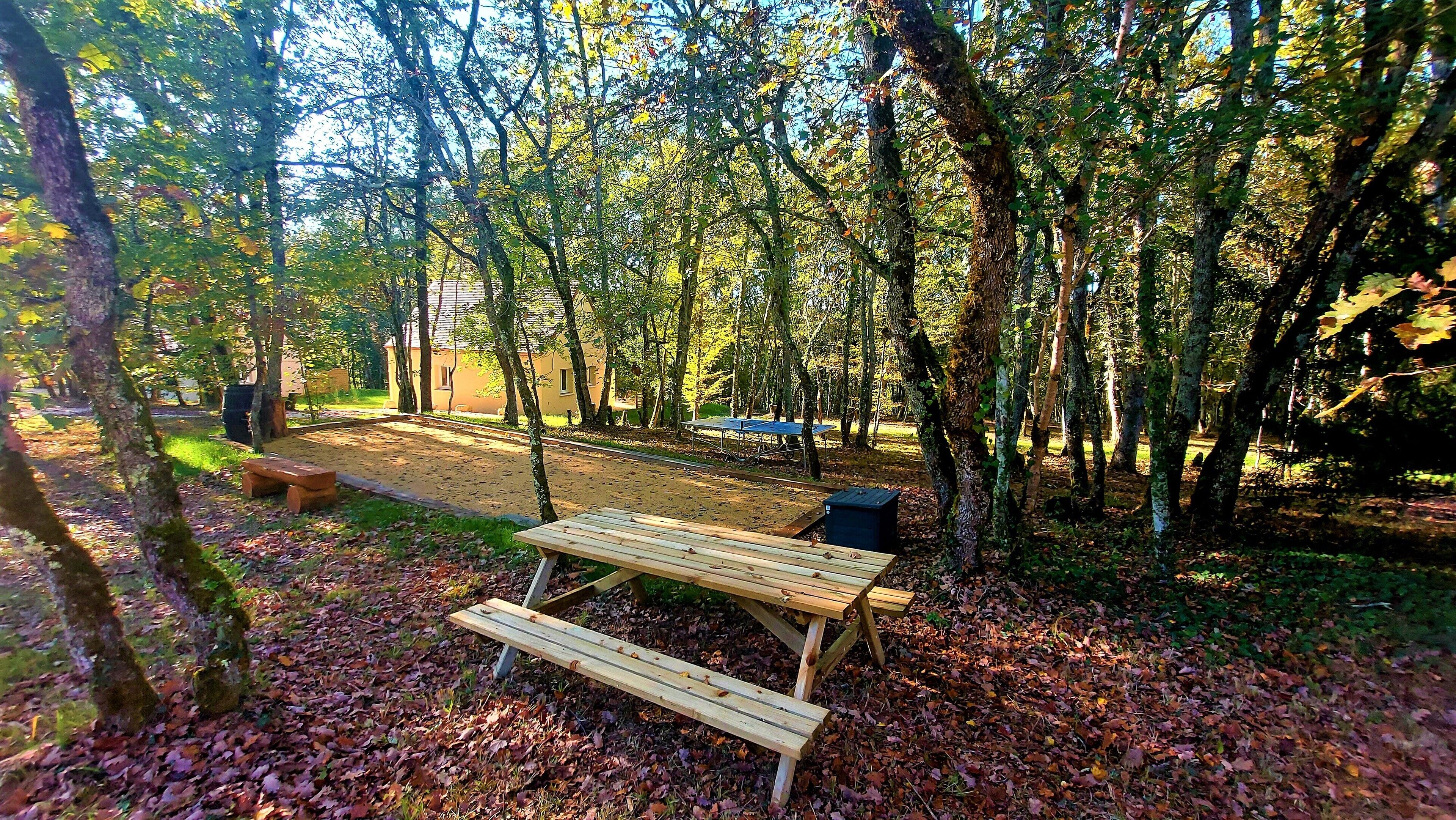 Une zone boisée équipée de tables de pique-nique et d’une borne de recharge alimentée par énergie solaire.