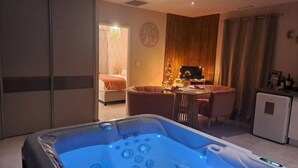 Et værelse med jacuzzi, spiseplads og tekøkken.