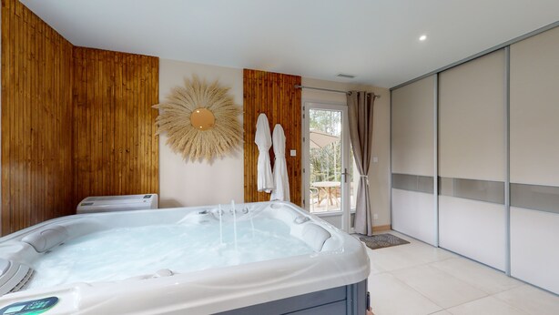 Et moderne badeværelse med jacuzzi, træpaneler, et stort spejl og udsigt til det fri.