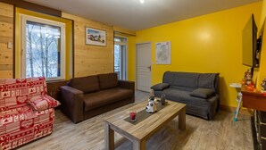 A living room with two sofas, a coffee table, and a wooden floor.