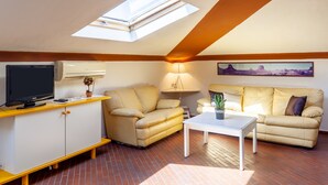 A cozy living room with a TV, sofa, and lamp. - Holiday Apartment "Loft parallela Lungomare posto auto" with A/C & Wi-Fi (Viareggio)
