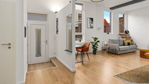 A modern interior with a dining area, a sofa, and a staircase. - MEL&BENS Loft 2 | Terrace | Design | Weserstadion (Bremen)