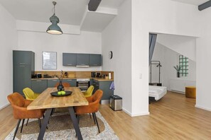 Een modern appartement met een eethoek, keuken en een slaapkamer met raam.