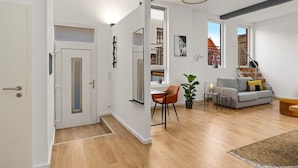 A modern interior with a dining area, a sofa, and a staircase. - MEL&BENS Loft 1+2 for 8 P. | terrace | sauna | Design | Weserstadion (Bremen)