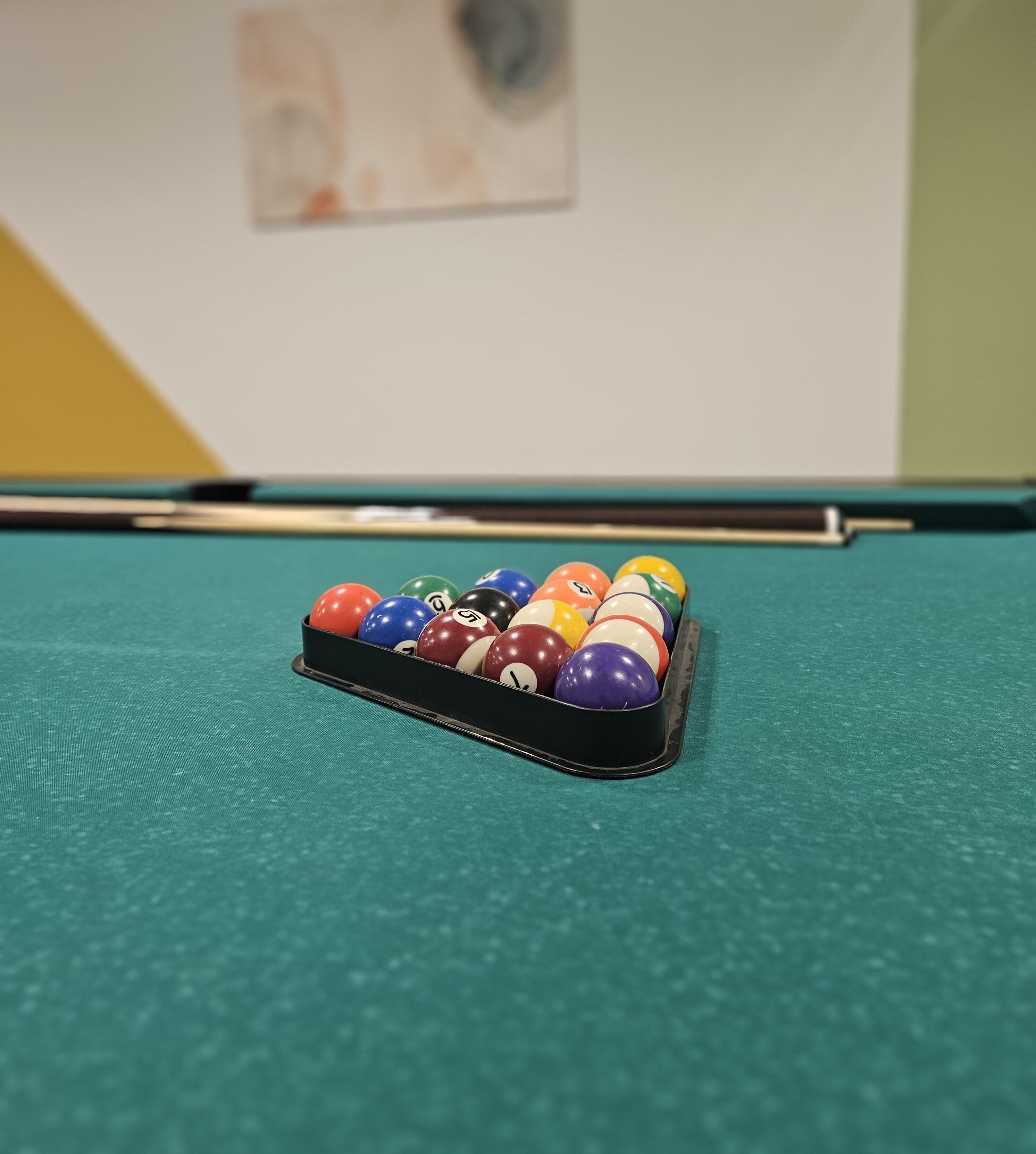 A pool table with a rack of billiard balls.