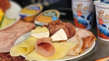 A variety of food items including sliced meats, cheeses, and packaged goods on a table.