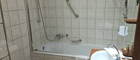 Un baño con bañera, inodoro y lavamanos.