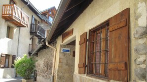Ein Steinhaus mit Holzhinterfenstern und Balkonen.