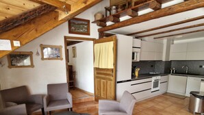 Ein gemütliches Wohnzimmer mit Kamin, Essbereich und einer Küche mit modernen Geräten.