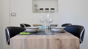 Una mesa de comedor con cuatro sillas, vasos transparentes y tazones.