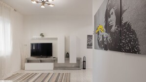 Una sala de estar moderna con un televisor de pantalla plana, chimenea y arte abstracto en la pared.