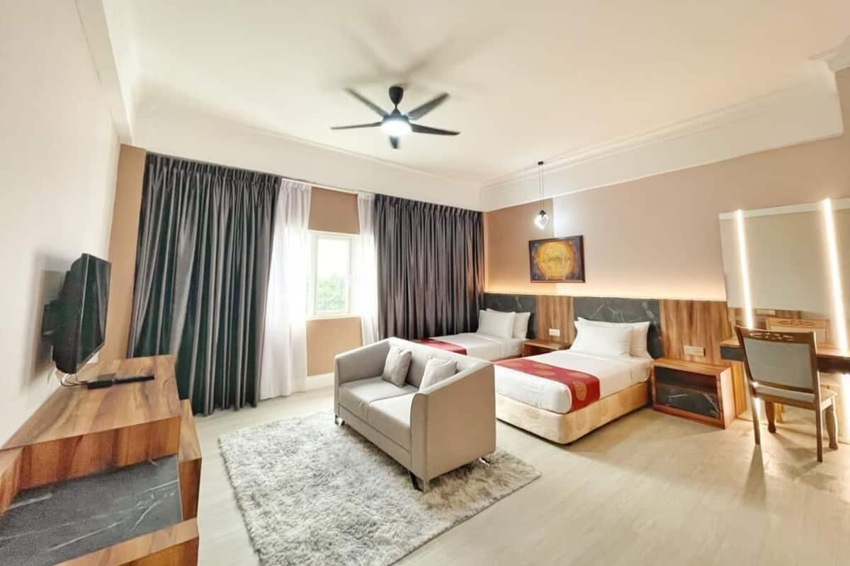Une chambre d’hôtel avec un lit, un canapé, un bureau et une télévision.