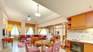 Un salon spacieux avec un coin repas, une cuisine dotée de meubles en bois et une grande fenêtre agrémentée de rideaux.