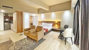 Une chambre d’hôtel comprenant un lit, un canapé, une table à manger et une kitchenette.