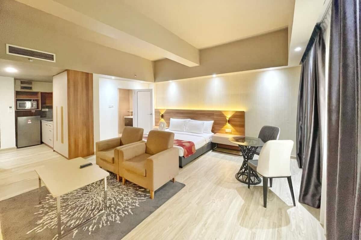 Une chambre d’hôtel comprenant un lit, un canapé, une table à manger et une kitchenette.