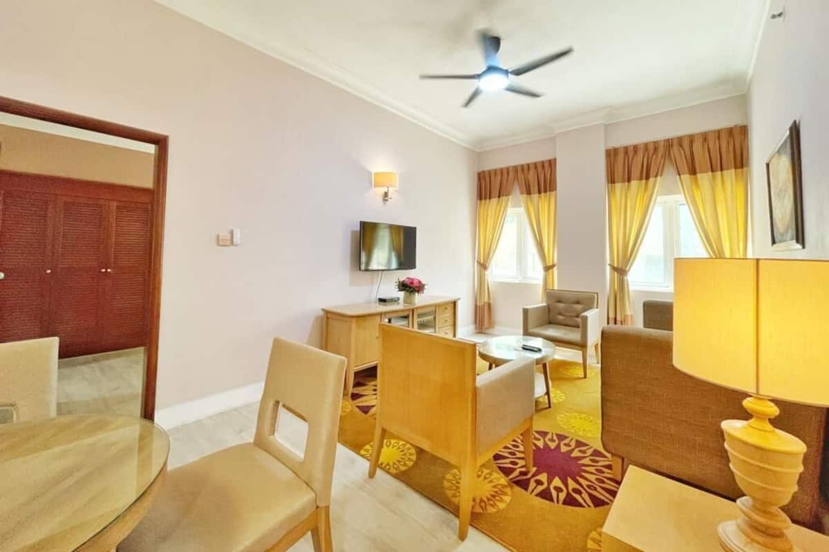 Une chambre d’hôtel équipée d’un coin repas, d’une télévision et d’un ventilateur de plafond.
