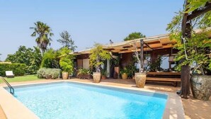Ein Schwimmbecken mit Holzterrasse und Blumentöpfen.