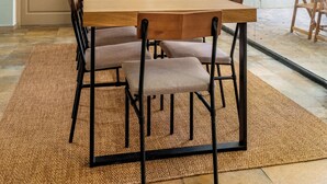 Een eethoek met een grote tafel, stoelen, een vaas en een lamp.